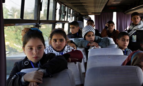 Palestinian children wait on a bus
